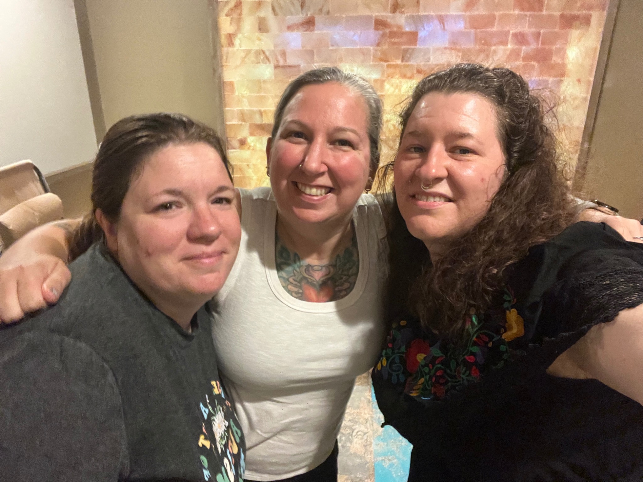 Three people smiling together in the Sweet Dreams salt room